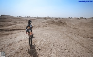 A woman in a futuristic outfit holding a gun.