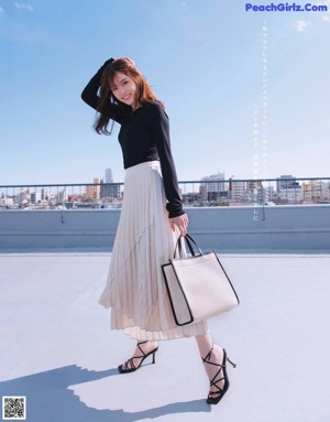 A woman with long brown hair is posing for a magazine.