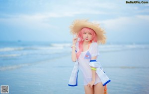 A woman in a straw hat is sitting in the water.