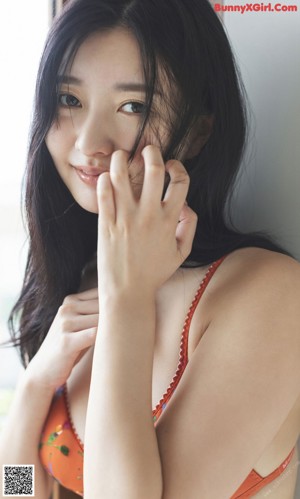 A close up of a woman with her hand on her chin.