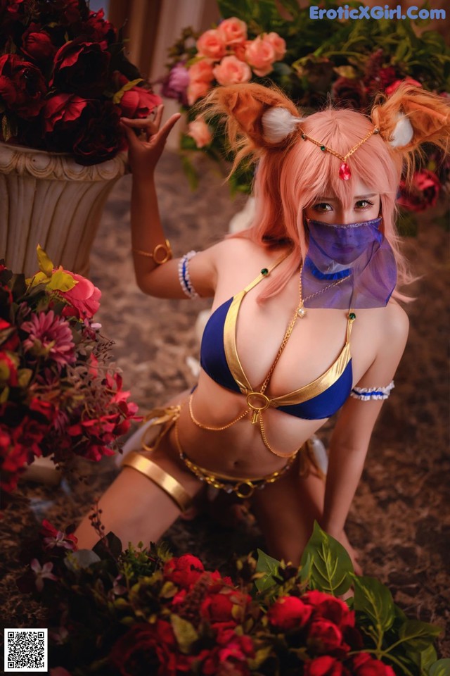 A woman in a bikini with a mask on and flowers around her.
