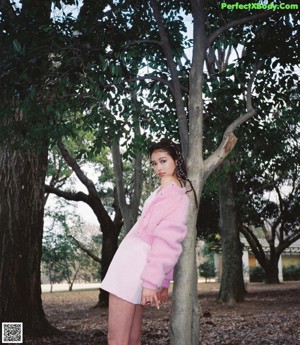 A woman with long black hair wearing a pink dress.