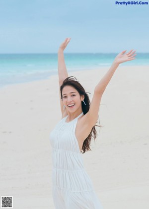 A woman in a white top and yellow skirt posing for a magazine.