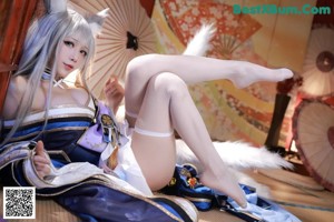 A woman in a blue and white outfit is sitting on a chair.