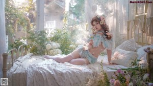 A woman laying on a bed with flowers in her hair.