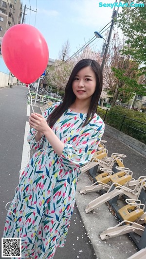 A woman in a yellow sweater smiles at the camera.