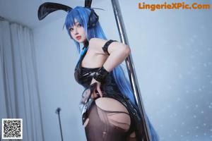 A woman in a black and blue outfit holding a sword.
