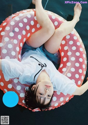 A woman laying on a bed with a teddy bear.