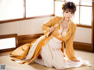 A woman in a red and white kimono sitting on a table.