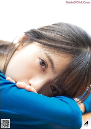 A young woman laying on the floor with a bottle of water in her hand.