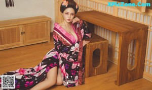 A woman in a kimono sitting on a wooden bench.