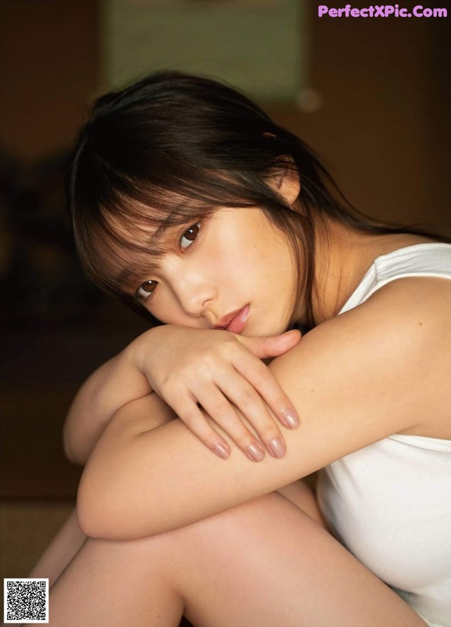 A woman sitting on the floor with her legs crossed.