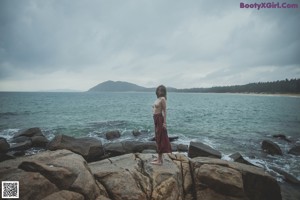 A woman standing in the water at the beach.