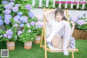 A woman in a white shirt and white stockings posing for a picture.