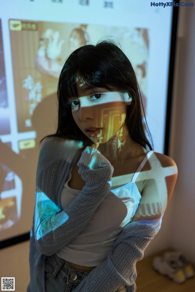 A woman standing in front of a projection screen.