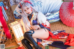 A woman in a kimono sitting on the floor.
