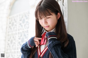 A young woman in a school uniform posing for a picture.