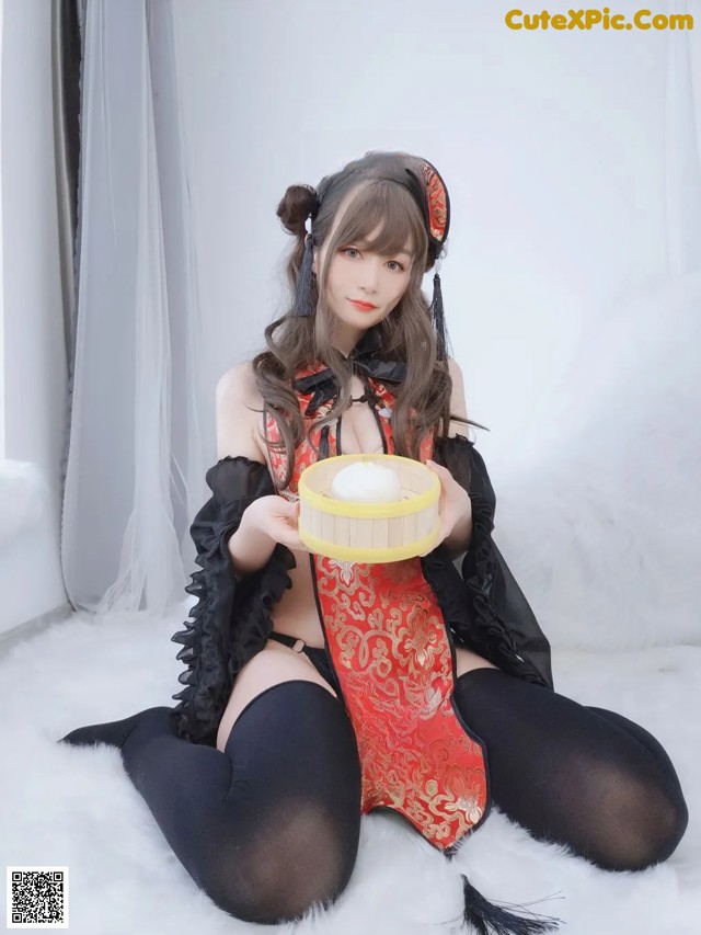 A woman in a red and black outfit holding a bowl of food.